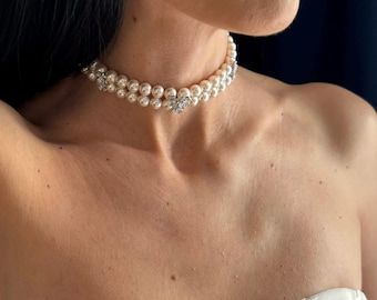 Närbild på en brud som bär ett elegant pärlhalsband i choker-stil.
